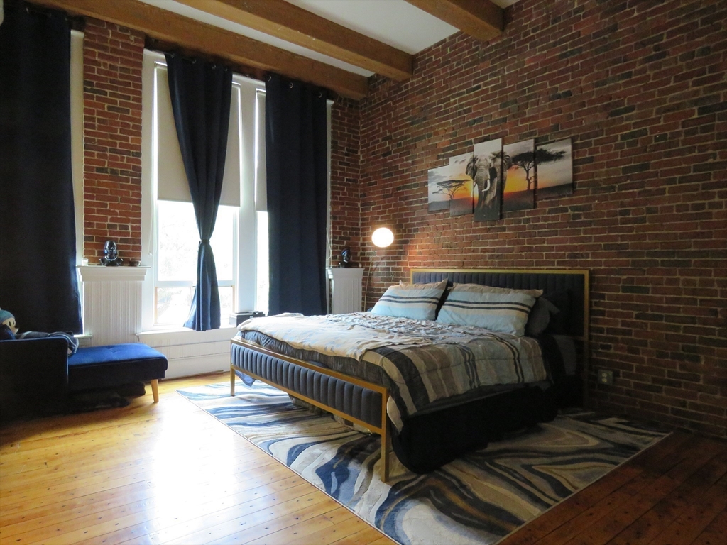 61 Market Street, Unit 2B Lowell, MA 01852 - Photo 8 of 20 a bedroom with a bed and a couch