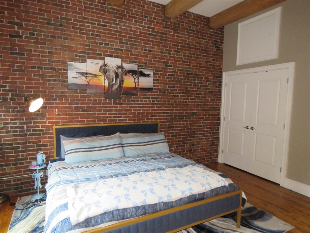 61 Market Street, Unit 2B Lowell, MA 01852 - Photo 9 of 20 a bedroom with a bed and a mirror