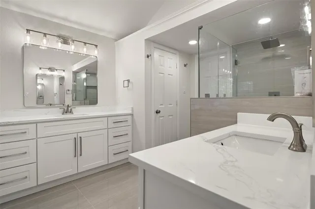 a bathroom with a sink a vanity a large mirror and shower