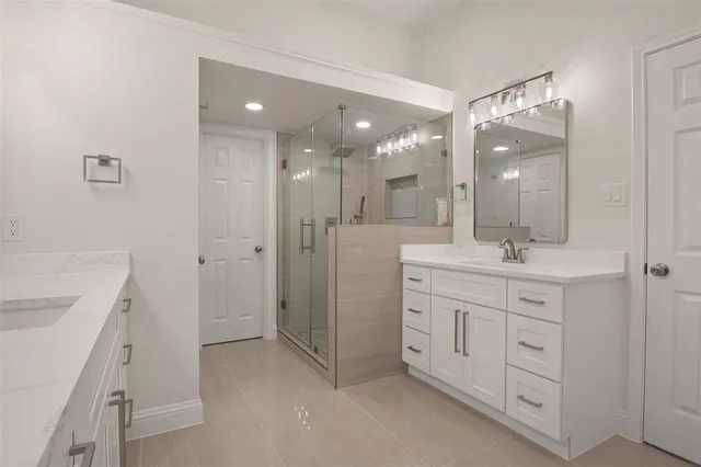a bathroom with a double vanity sink mirror and shower