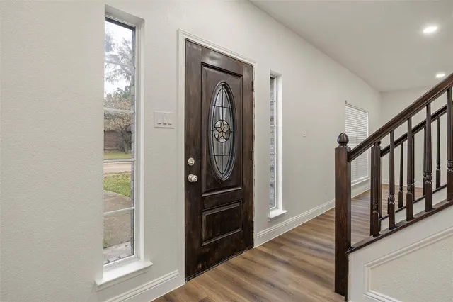 a view of a hallway with wooden floor and stairs