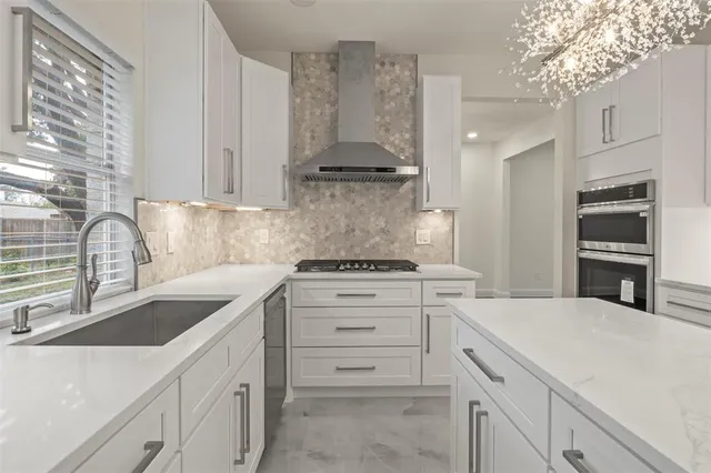 a kitchen with white cabinets and appliances