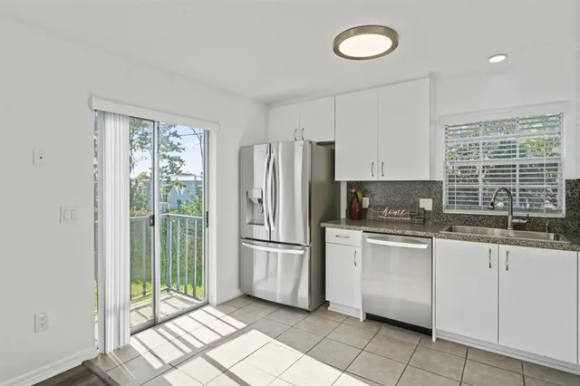 a kitchen with granite countertop a refrigerator and a sink