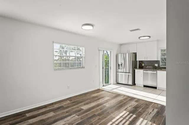 a view of kitchen with stainless steel appliances refrigerator oven and cabinets