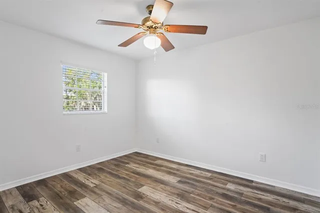 an empty room with a window and a fan