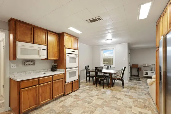 a kitchen with a sink table and chairs
