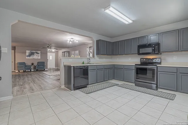 a kitchen with stainless steel appliances granite countertop a stove top oven a sink dishwasher and a refrigerator