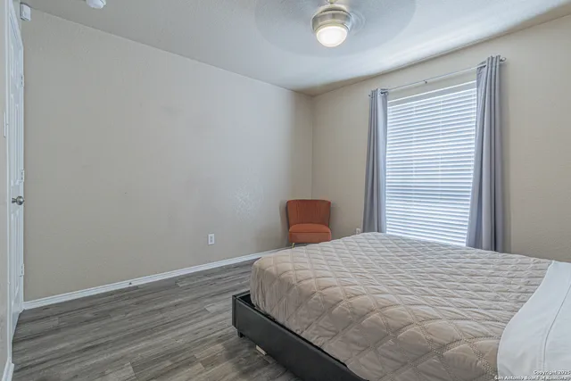 a large bed sitting in a bedroom next to a window
