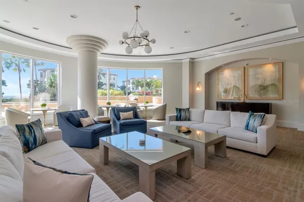 a living room with furniture a fireplace and a chandelier