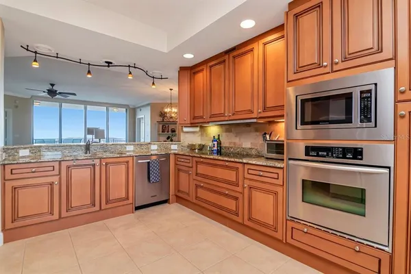 a kitchen with stainless steel appliances granite countertop a stove a sink dishwasher and a microwave oven with cabinets