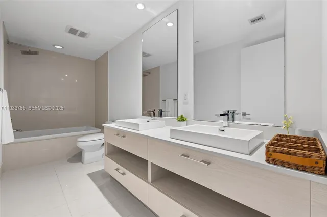 a bathroom with a double vanity sink toilet a mirror and shower