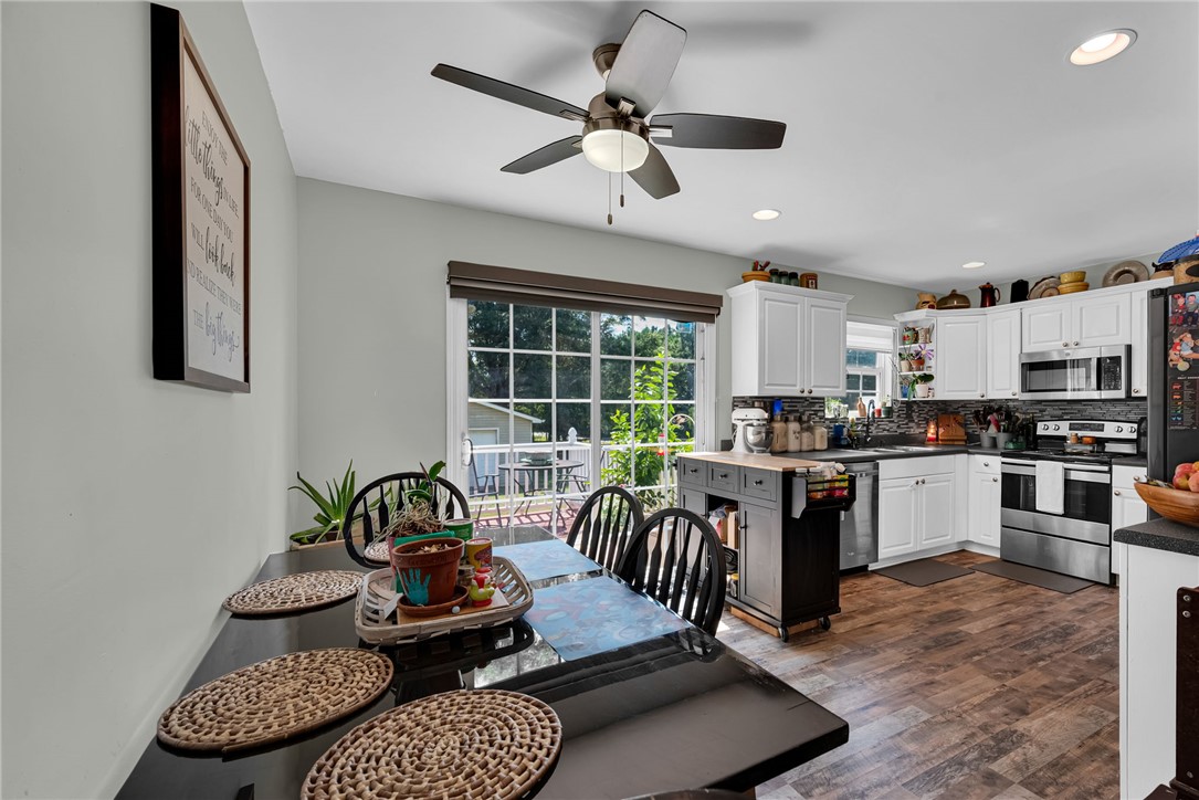 247 Clardy Road Pelzer, SC 29669 - Photo 28 of 34 Rich wood-look flooring runs beneath high ceilings and classic white cabinetry in this bright space.