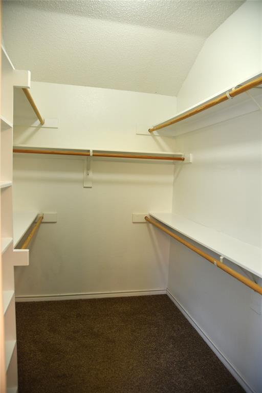 1526 Pebblestone Court Allen, TX 75002 - Photo 17 of 28 Primary Bedroom Walk-in closet featuring white built-in shelving, wood clothing rods, and brown carpet flooring