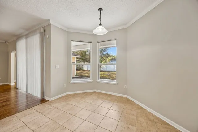 an empty room with wooden floor windows and cabinet