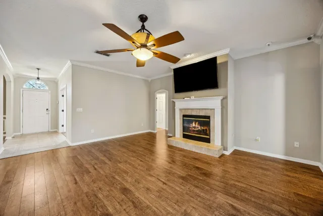 a view of a livingroom with a fireplace a ceiling fan and hardwood floor