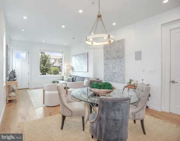 a dining room with furniture a chandelier and wooden floor