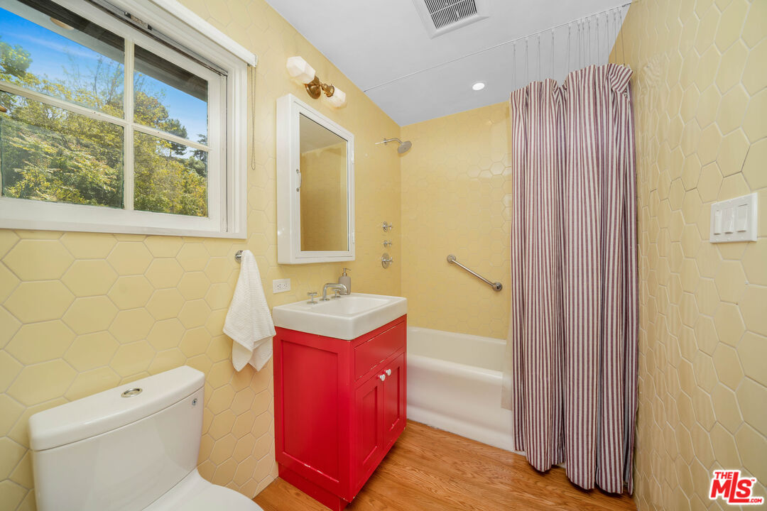 4124 Dundee Drive Los Angeles, CA 90027 - Photo 25 of 54 a bathroom with a granite countertop sink a toilet and shower curtain