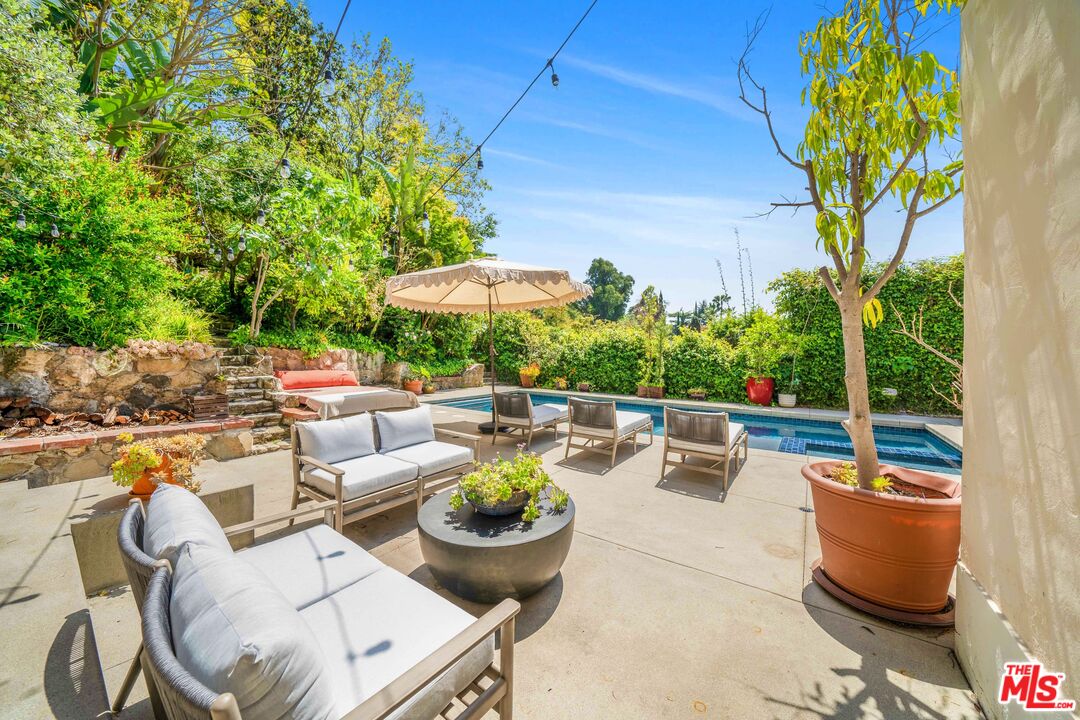 4124 Dundee Drive Los Angeles, CA 90027 - Photo 38 of 54 a view of a patio with couches and a table and chairs under an umbrella