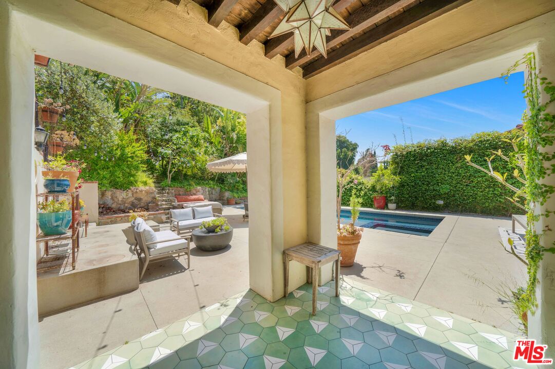 4124 Dundee Drive Los Angeles, CA 90027 - Photo 43 of 54 a view of a patio with table and chairs potted plants with floor to ceiling window