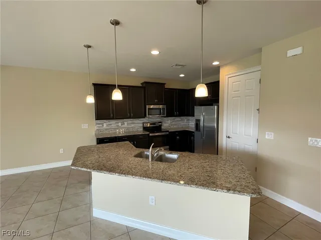 a large kitchen with kitchen island a sink stainless steel appliances and a counter top