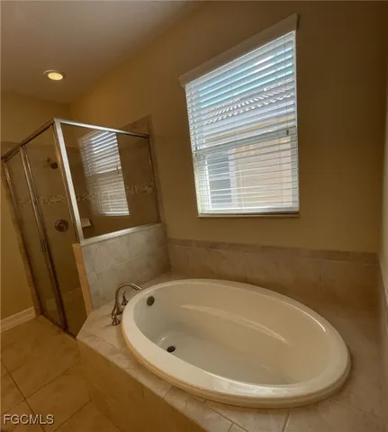 a bathroom with a tub and large window