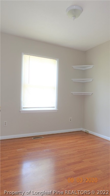 5856 Columbine Road Fayetteville, NC 28306 - Photo 12 of 25 an empty room with wooden floor and windows