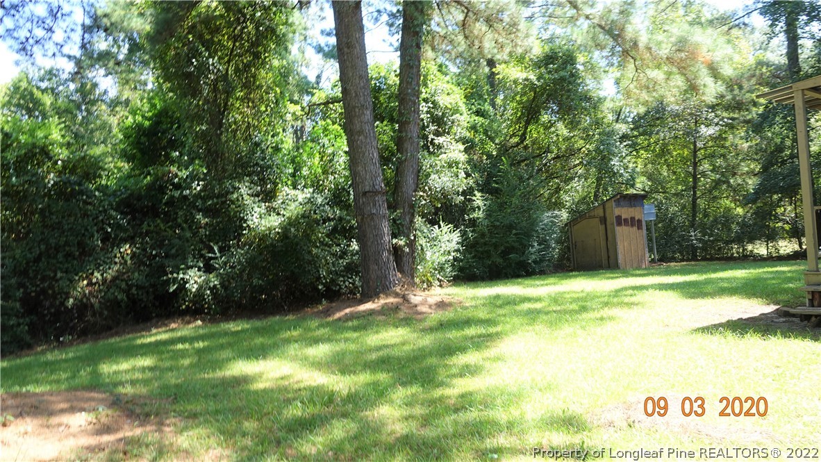 5856 Columbine Road Fayetteville, NC 28306 - Photo 22 of 25 a backyard of a house with a bench and trees