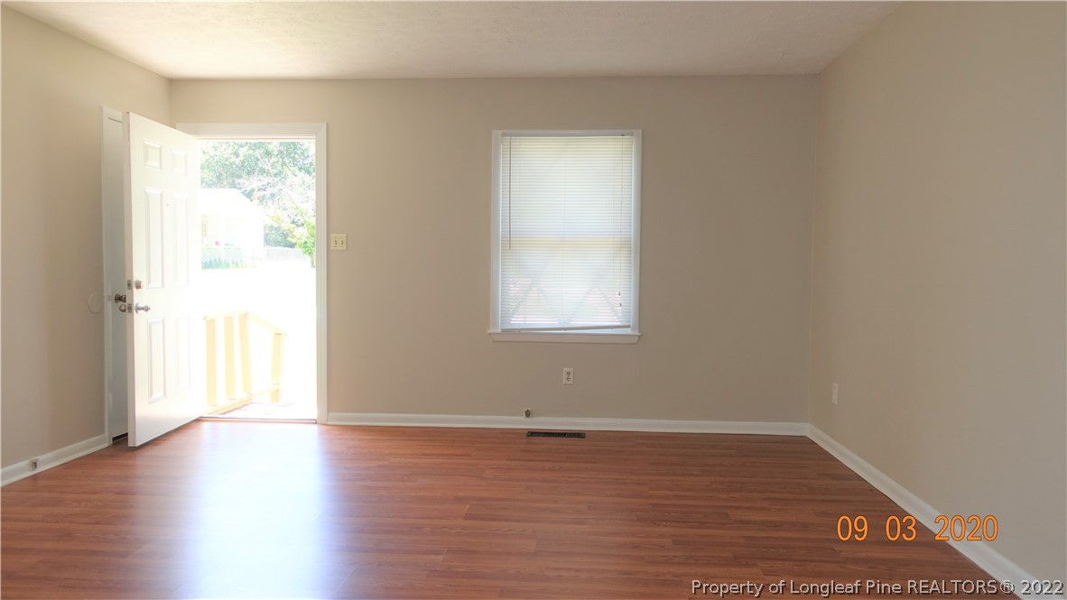 5856 Columbine Road Fayetteville, NC 28306 - Photo 6 of 25 an empty room with wooden floor and windows