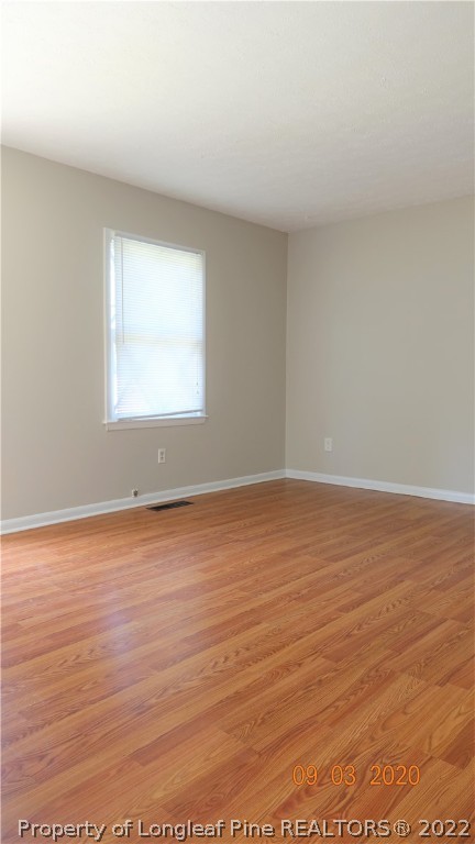 5856 Columbine Road Fayetteville, NC 28306 - Photo 8 of 25 an empty room with wooden floor and windows