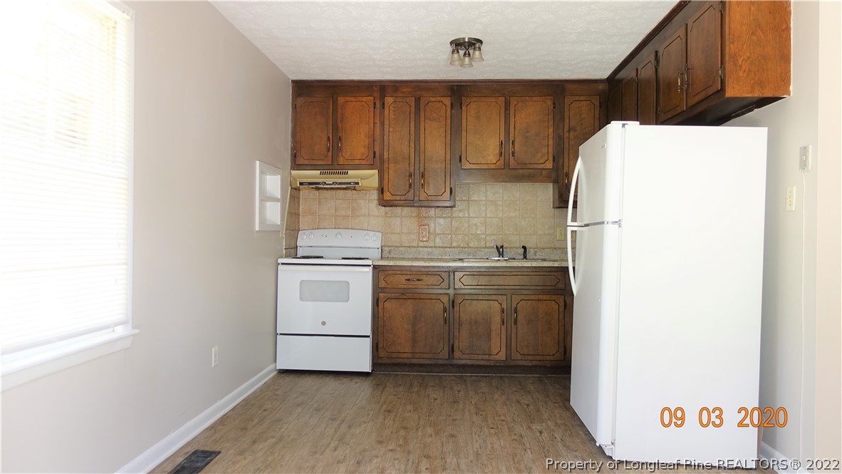 5856 Columbine Road Fayetteville, NC 28306 - Photo 9 of 25 a kitchen with a white stove refrigerator and cabinets
