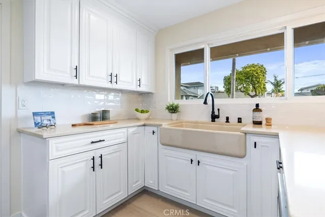a kitchen with white cabinets and white appliances
