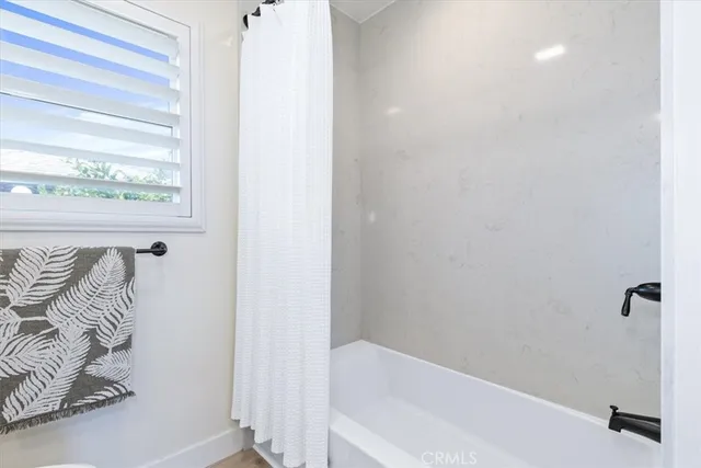 an empty room with wooden floor and ceiling fan