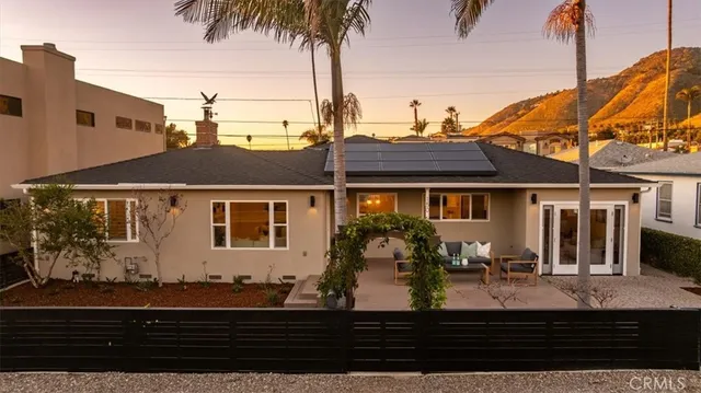 an aerial view of a house with a yard wooden table and chairs
