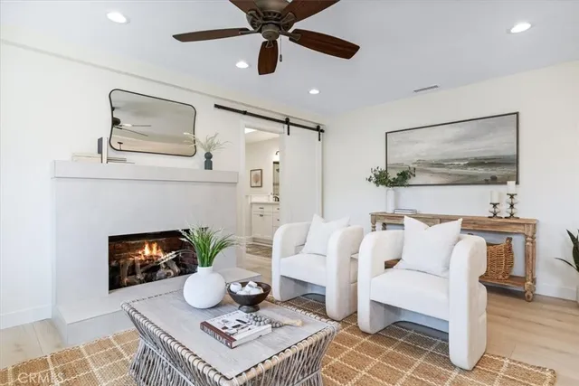 a living room with furniture a fireplace and wooden floor