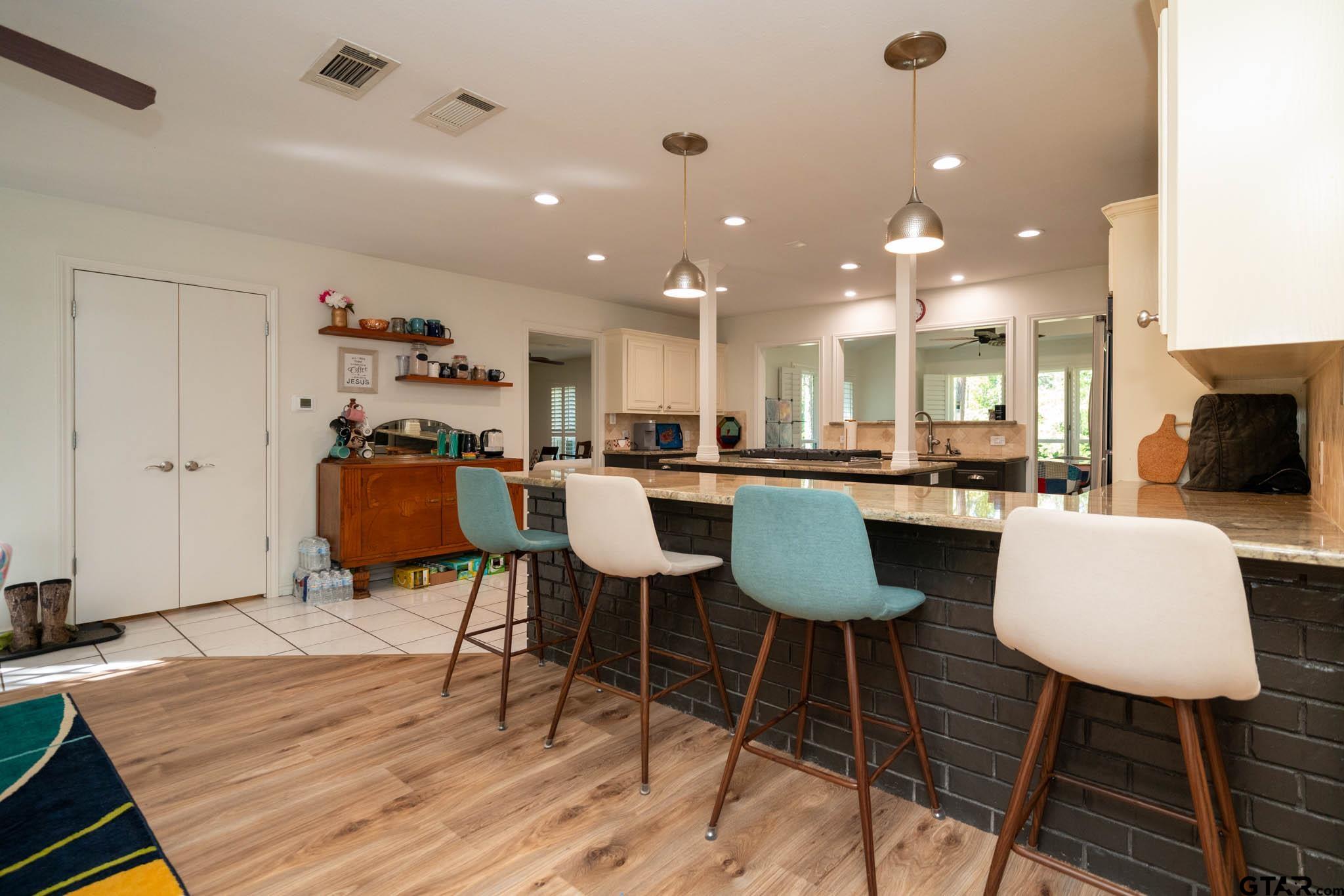 431 Gifford Street Rusk, TX 75785 - Photo 14 of 48 a dining room with stainless steel appliances kitchen island granite countertop a table chairs and a refrigerator