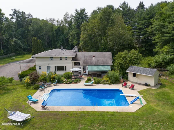 an aerial view of a house with pool lake view and mountain view