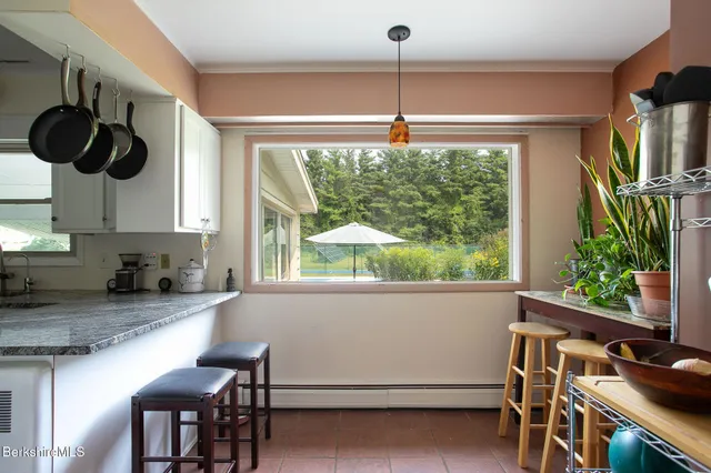 a kitchen with stainless steel appliances granite countertop a stove and a view of living room