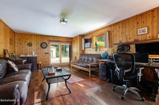 a living room with furniture a piano and wooden floor