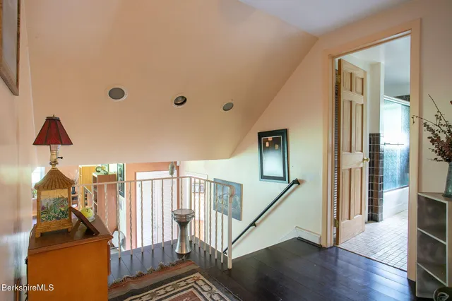 a view of a hallway with wooden floor and stairs