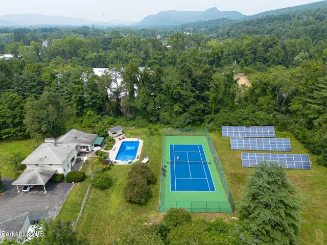 an aerial view of a house with pool lake view and mountain view