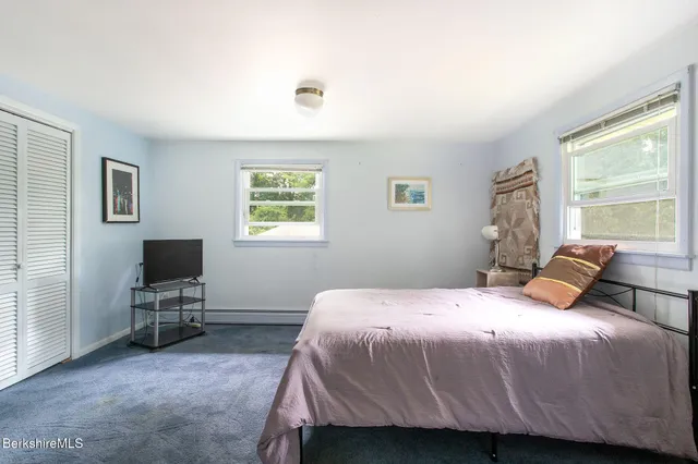 a bedroom with a bed tv and window