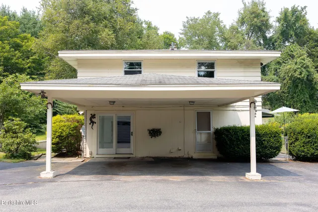 a view of a white house with a large window and plants