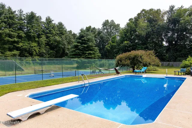 a view of a swimming pool with a yard and sitting area