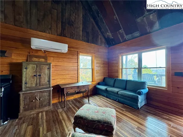 a living room with furniture a wooden floor and next to a window