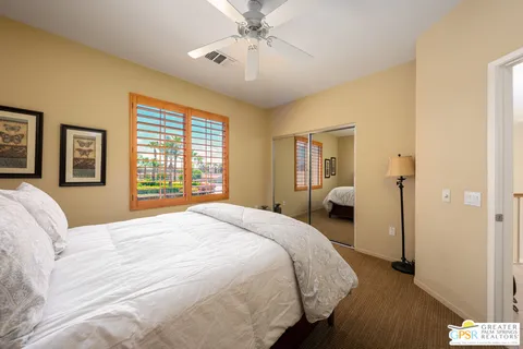 a spacious bedroom with a large bed and a chandelier