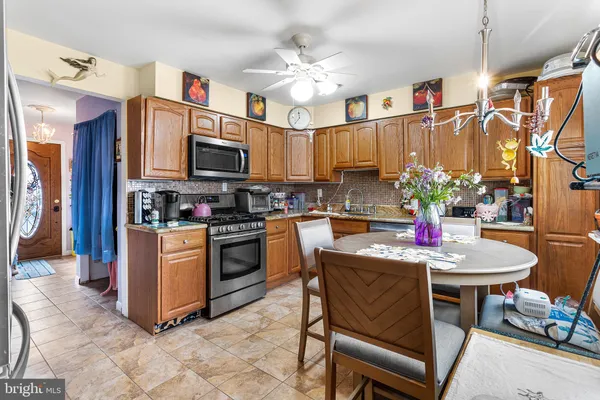 a kitchen with stainless steel appliances granite countertop a stove top oven a sink a dining table and chairs