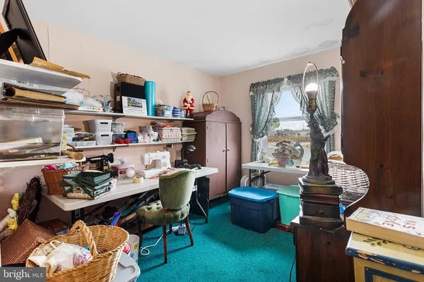 a work room with furniture a rug and a window
