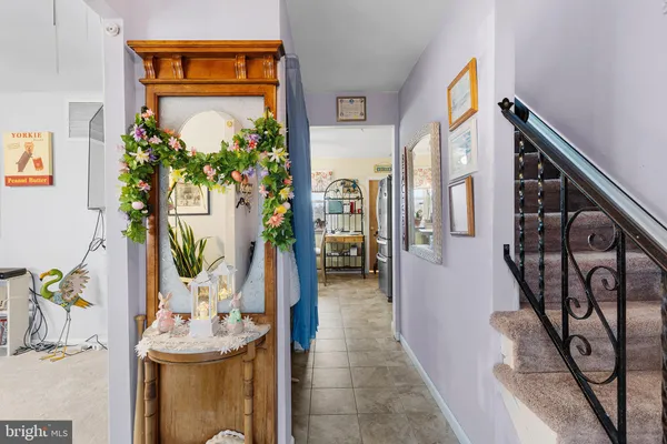 a hallway with painting on the wall and a potted plant