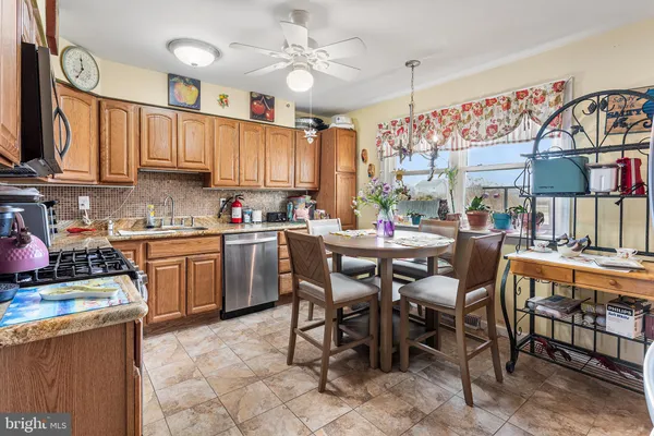 a kitchen with stainless steel appliances a table chairs and a refrigerator