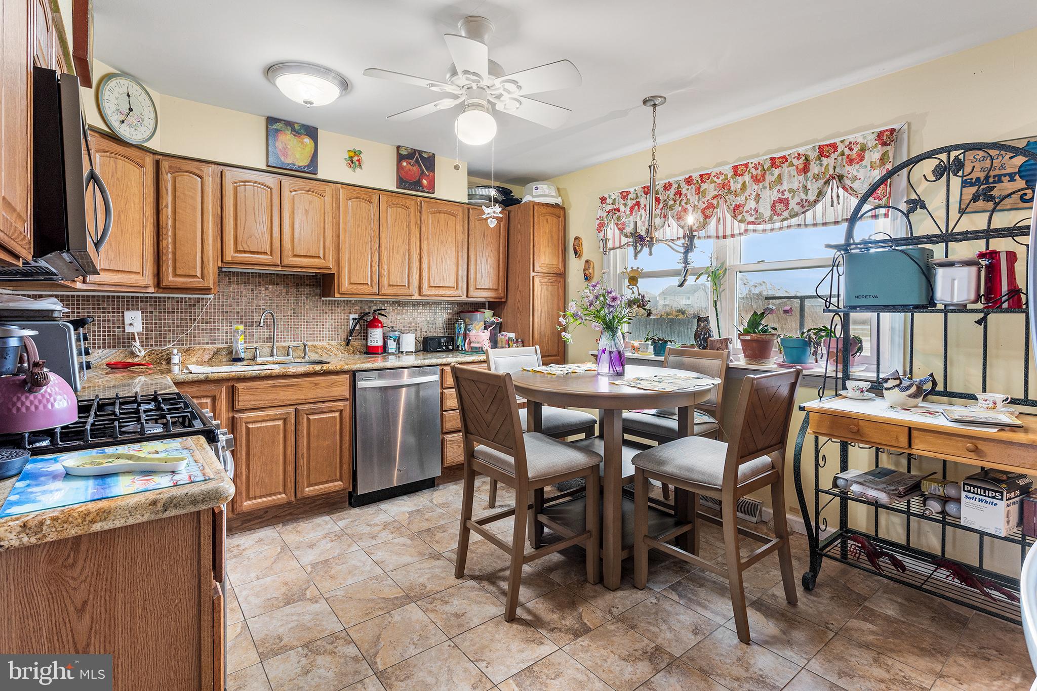 45 Heald Road Brigantine, NJ 08203 - Photo 10 of 25 a kitchen with stainless steel appliances a table chairs and a refrigerator